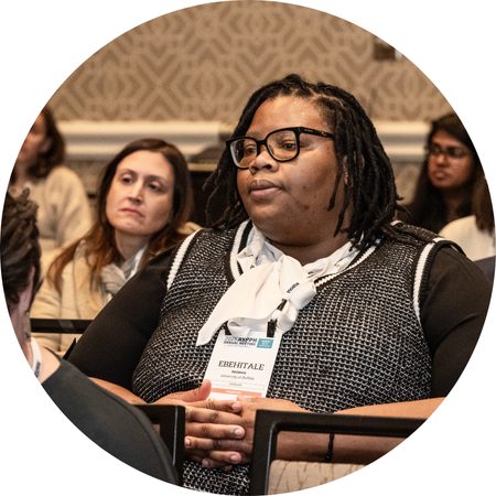 Audience members watching a panel