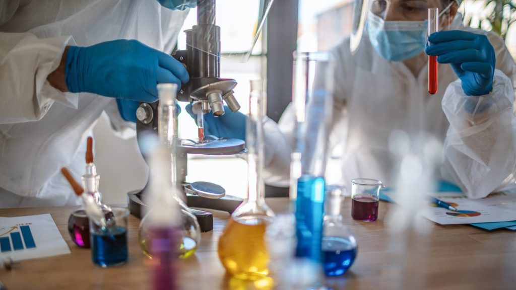 scientists running tests with test tubes and microscope