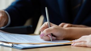 Close-up Image of someone signing documents